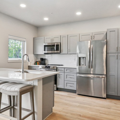 kitchen with grey cabinents and stainless steel appliances