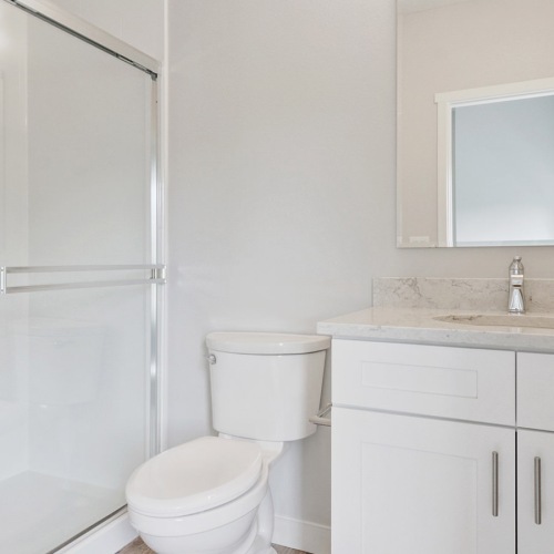 bathroom with sing mirror toilet and glass shower